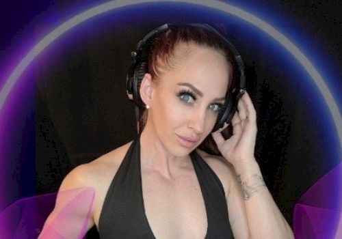 A person is wearing a black halter top, a headset, and has a hand on their hip, standing in front of a dark background with purple and blue circular graphics.