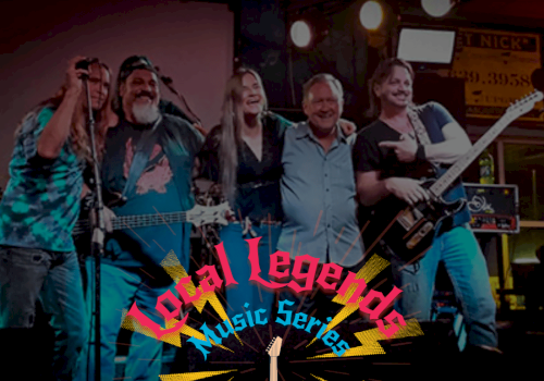 A rock band performing on stage, five members with guitars and microphones, colorful &ldquo;Vocal Legends&rdquo; logo and neon lights behind them.